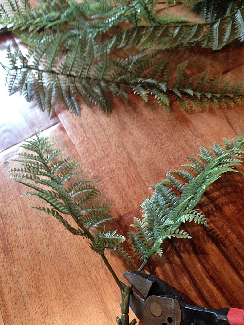 He clipped plastic ferns apart to make sprigs for the branches.