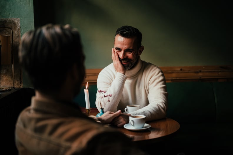 Two Men on Date in Restaurant Sitting at Table With Two Coffees
