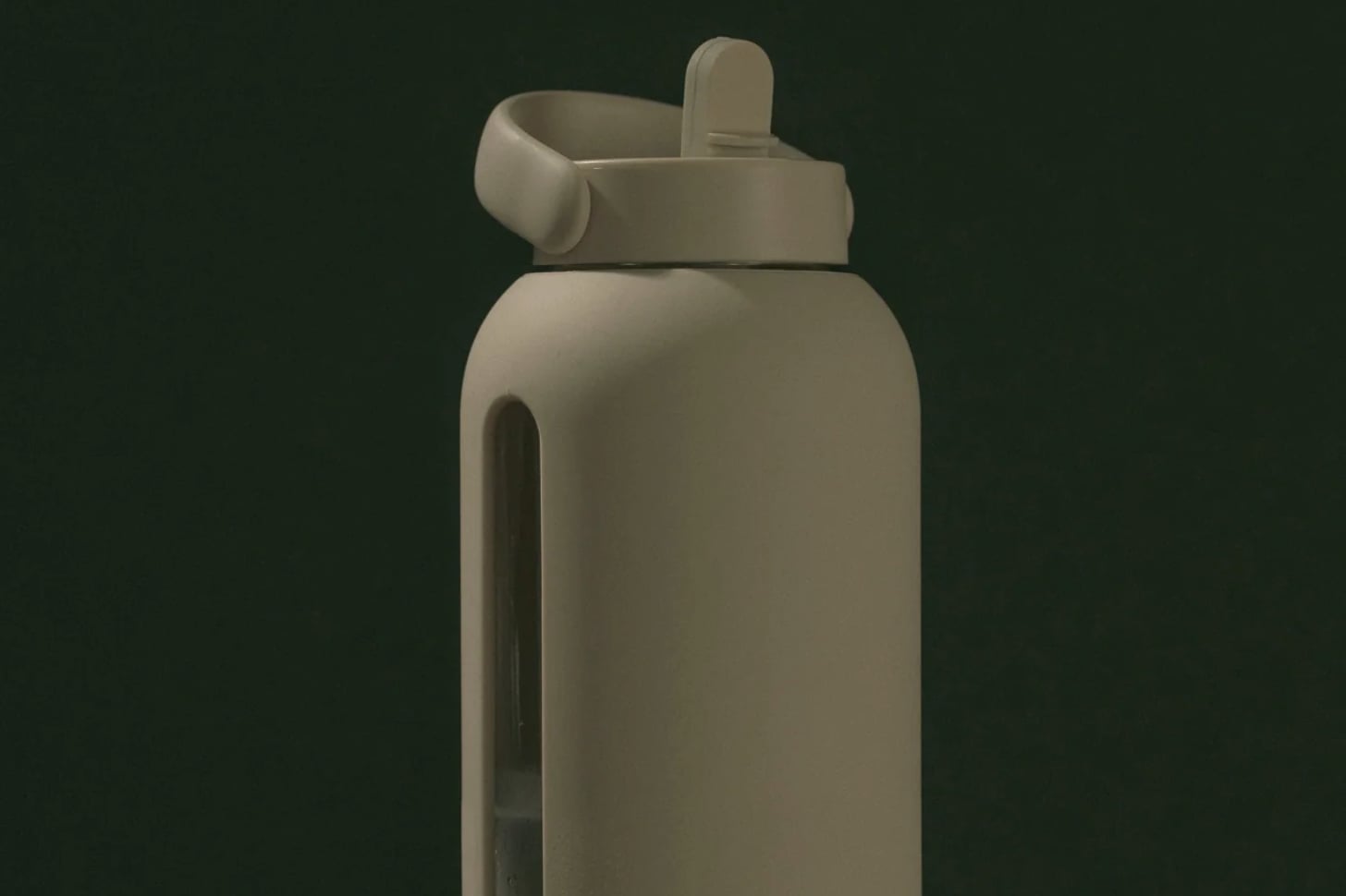 Tan Bink water bottle on dark backdrop.