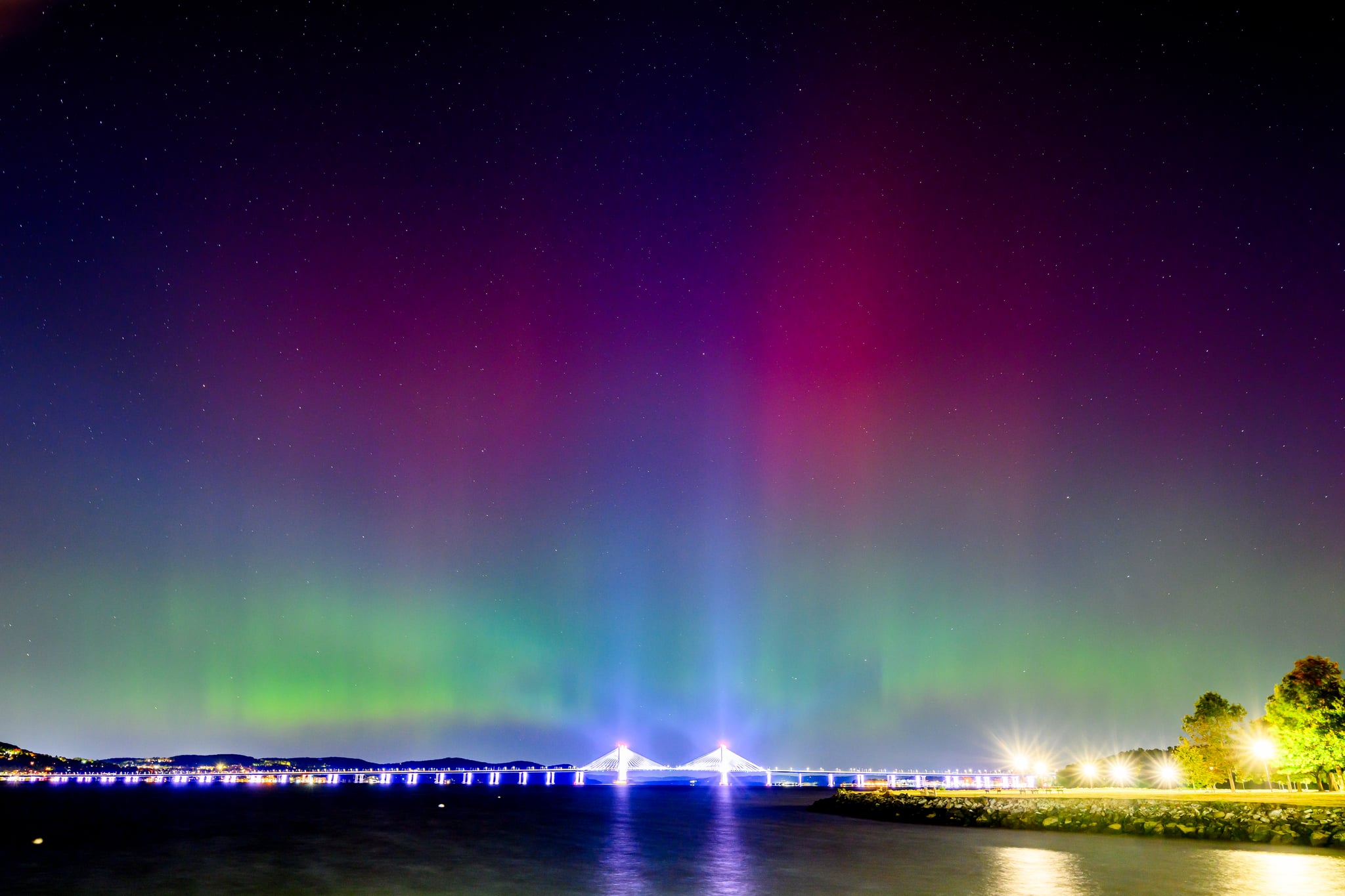 The Northern Lights or Aurora Borealis are visible over the Tappan Zee or Governor Mario M. Cuomo Bridge Bridge in New York City.