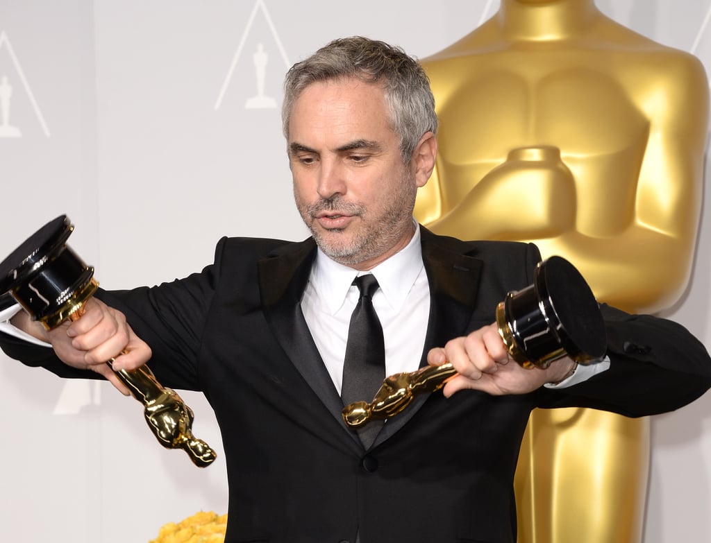 Alfonso Cuarón looked like he was reenacting a scene from Gravity with his two Oscars — one for best director and one for best film editing.