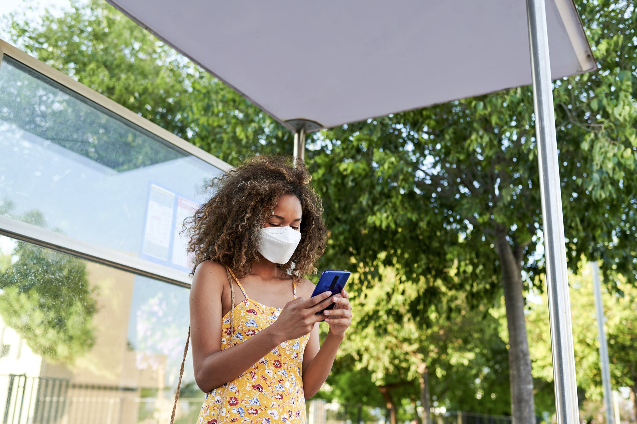 Woman with protective mask at the bus stop