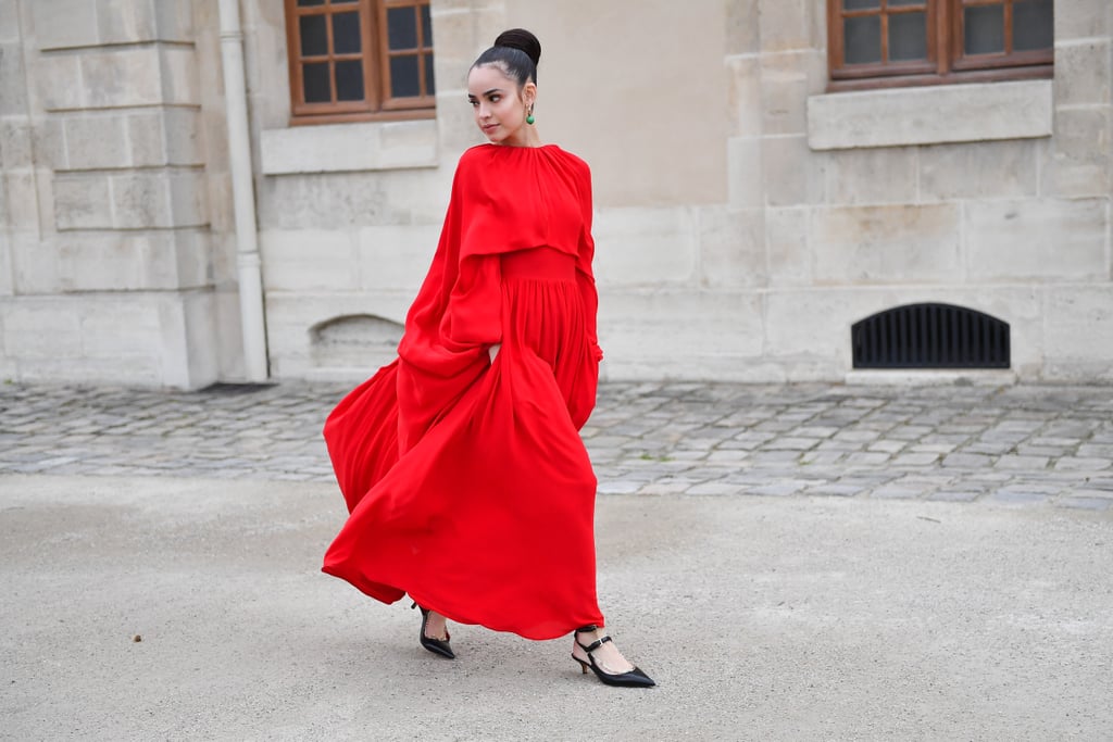 Wearing a red Valentino dress at the Valentino show during Paris Fashion Week in March 2019.