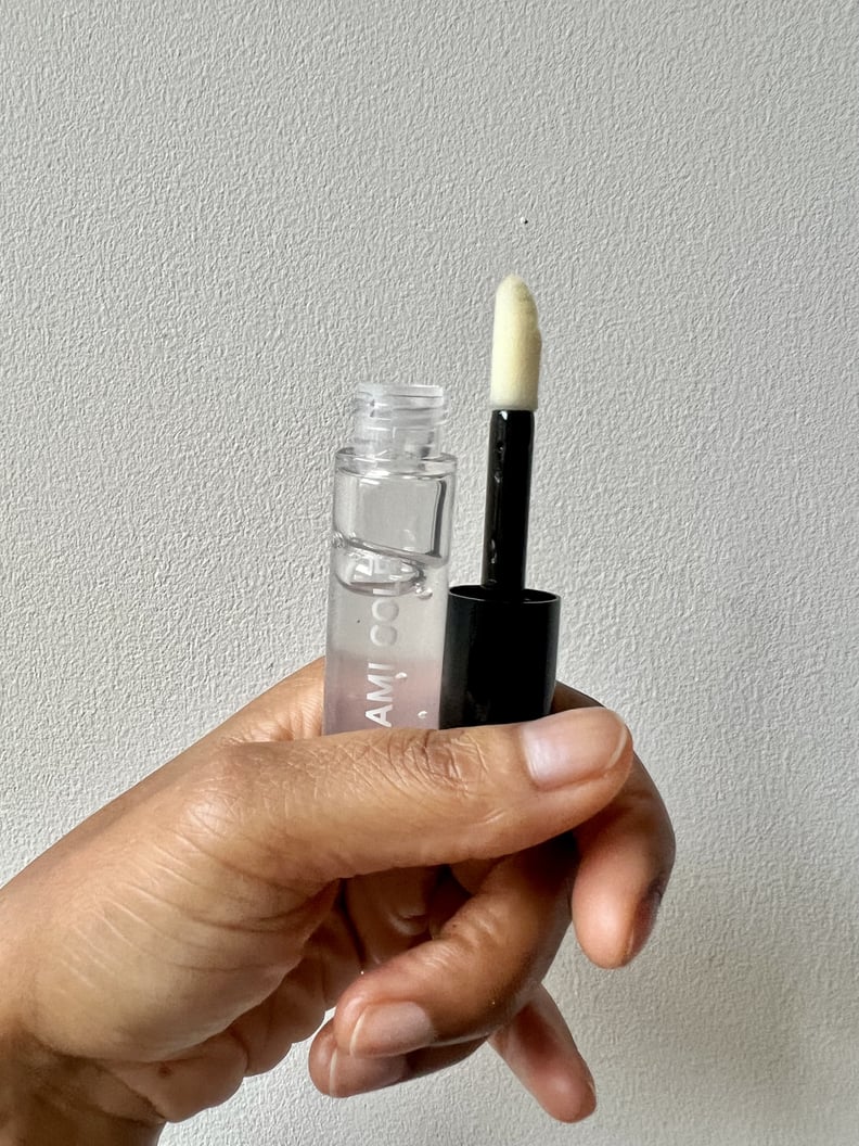 The doe-foot applicator of the clear Ami Colé Hydrating Lip Treatment Oil.