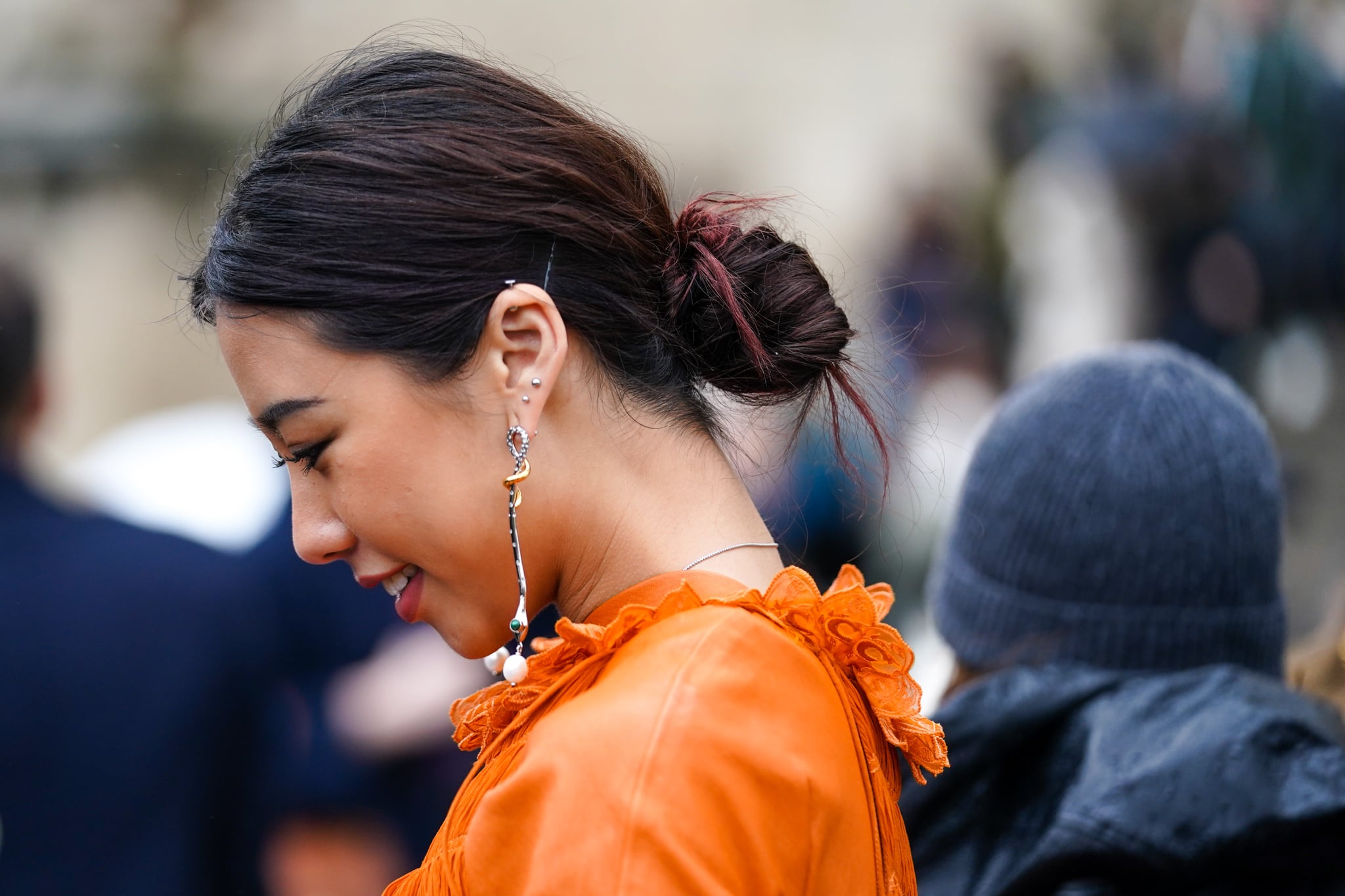 PARIS, FRANCE - FEBRUARY 27: A guest wears an orange dress with embroidery on the collar, long earrings, outside Chloe, during Paris Fashion Week - Womenswear Fall/Winter 2020/2021, on February 27, 2020 in Paris, France. (Photo by Edward Berthelot/Getty Images)