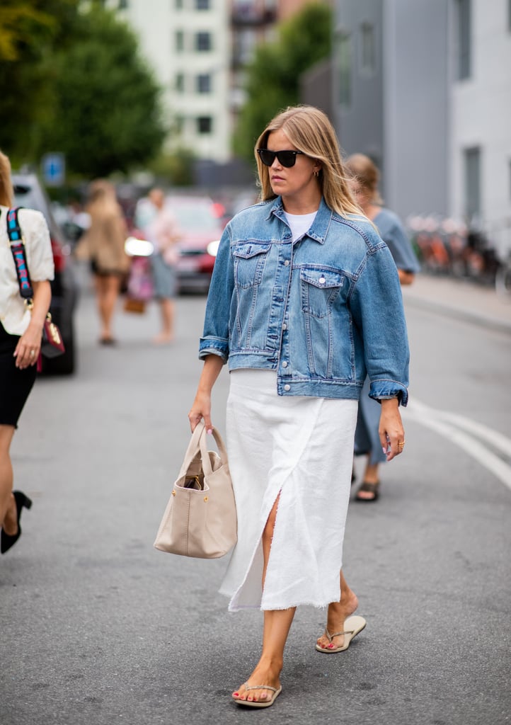 Styling a white dress and denim jacket with a beige pair of Havaianas.