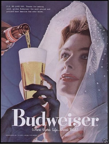 This 1957 Budweiser ad shows a woman in virginal white looking up at her male beer provider. A bit submissive, no?