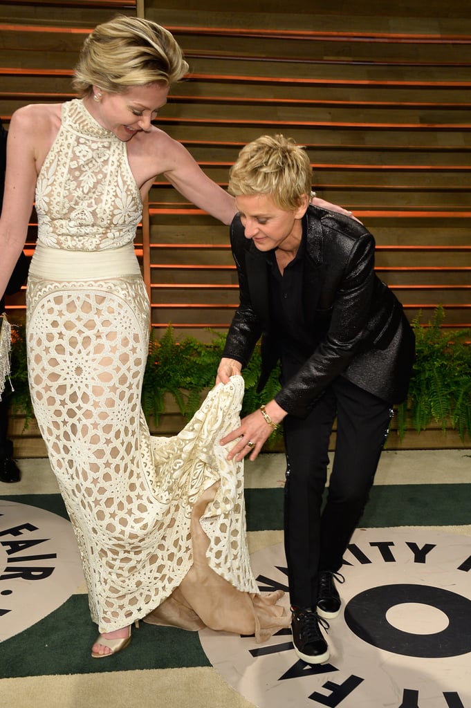 Ellen DeGeneres helped her wife, Portia de Rossi, out with her train while they posed outside the Vanity Fair bash.