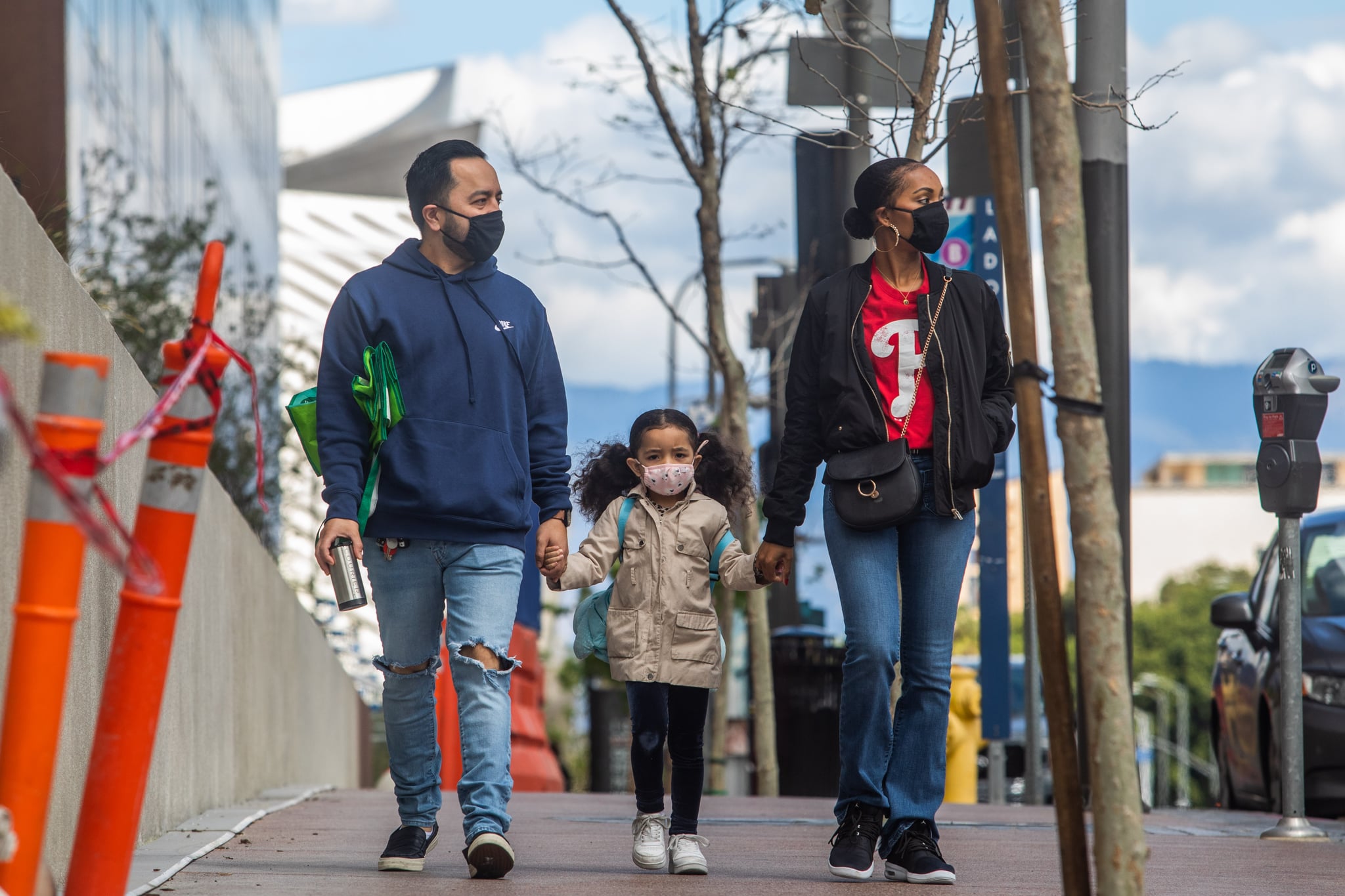 A family walks wearing masks in Downtown Los Angeles on March 22, 2020, during the coronavirus (COVID-19) outbreak. - The US president on March 22 said he had ordered the deployment of emergency medical stations with capacity of 4,000 hospital beds to coronavirus hotspots around the United States. (Photo by Apu GOMES / AFP) (Photo by APU GOMES/AFP via Getty Images)