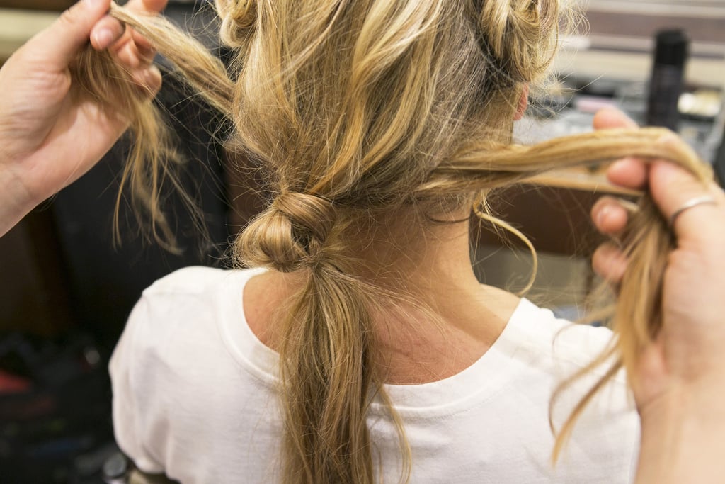Now that you have the top of your look finished, it's time to revisit the loose ponytail and the hair along your neck. Split the loose hair underneath the ponytail into two even sections as shown here.