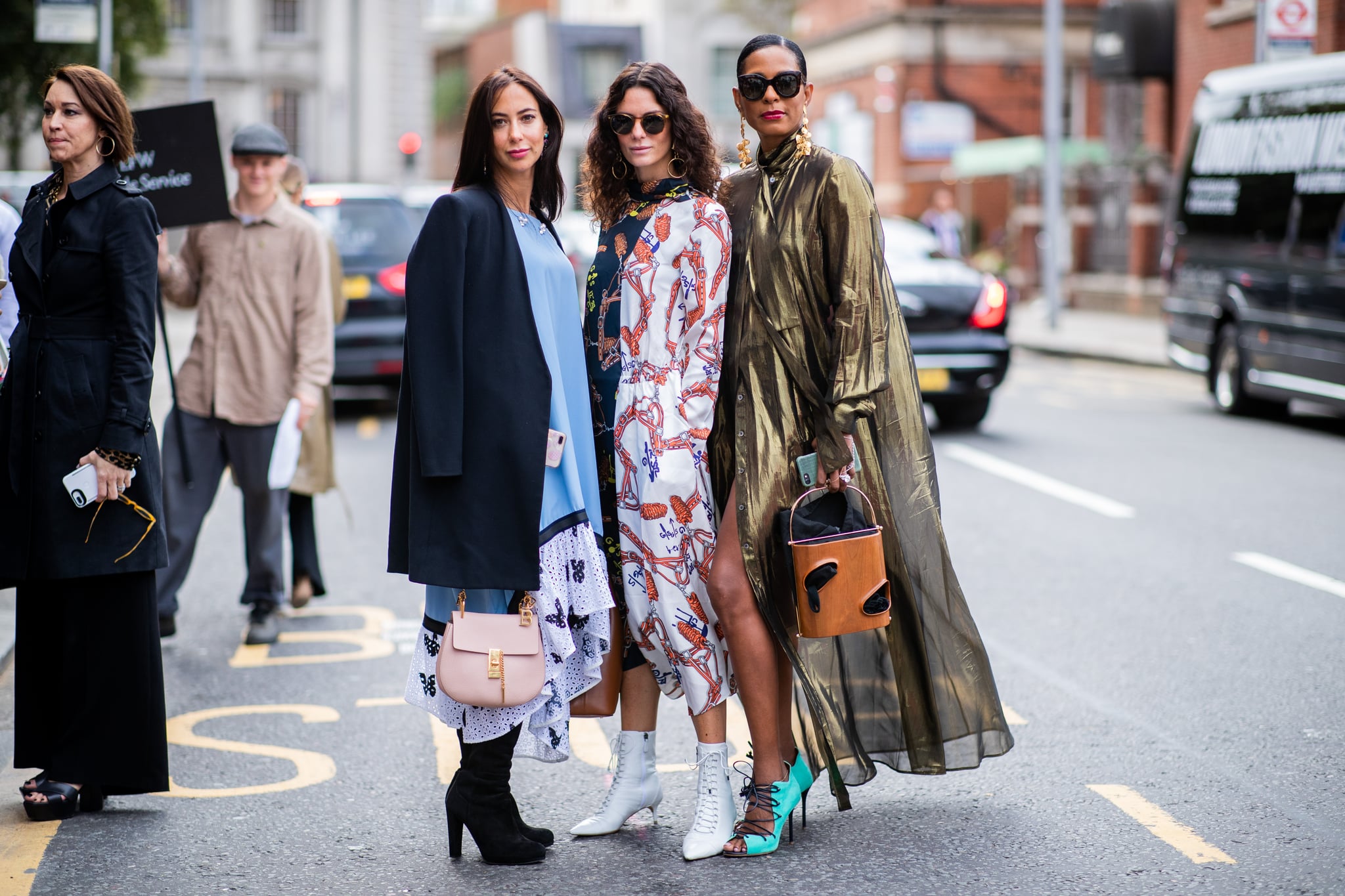 LONDON, ENGLAND - SEPTEMBER 18: A guest  wearing pink Chloe bag, blue dress, Hedvig Sagfjord Opshaug wearing two tone dress with print, brown leather bag, white ankle boots and a guest wearing golden coat is seen outside Natasha Zinko during London Fashion Week September 2018 on September 18, 2018 in London, England. (Photo by Christian Vierig/Getty Images)