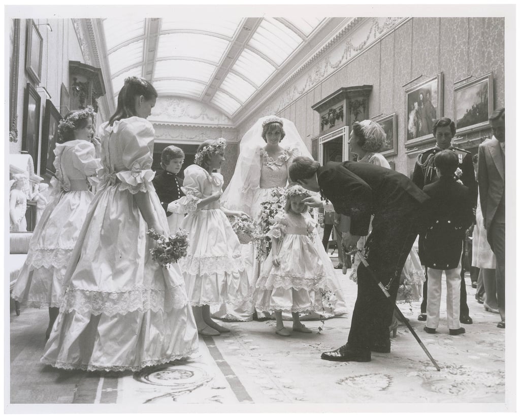Prince Andrew kneeled down to talk to Clementine Hambro while Princess Diana and Princess Margaret look on.