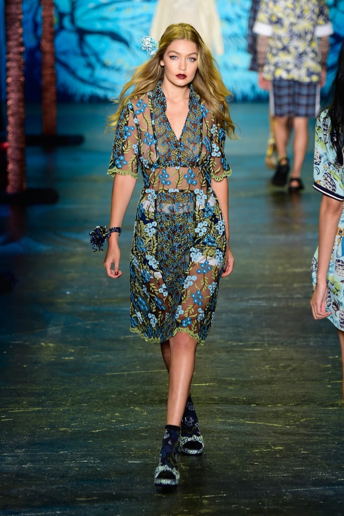 Gigi also walked the Anna Sui runway in a sheer, knee-length collared dress. Gigi’s vampy red lips were contrasted by the blue and green floral embroidery on her design. We’ll call this the cool, ethereal version of the naked dress!