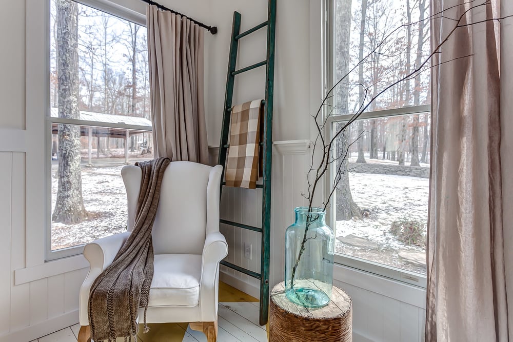 The wingback chair and ladder styled with a throw blanket make for an Tennesse Storybook