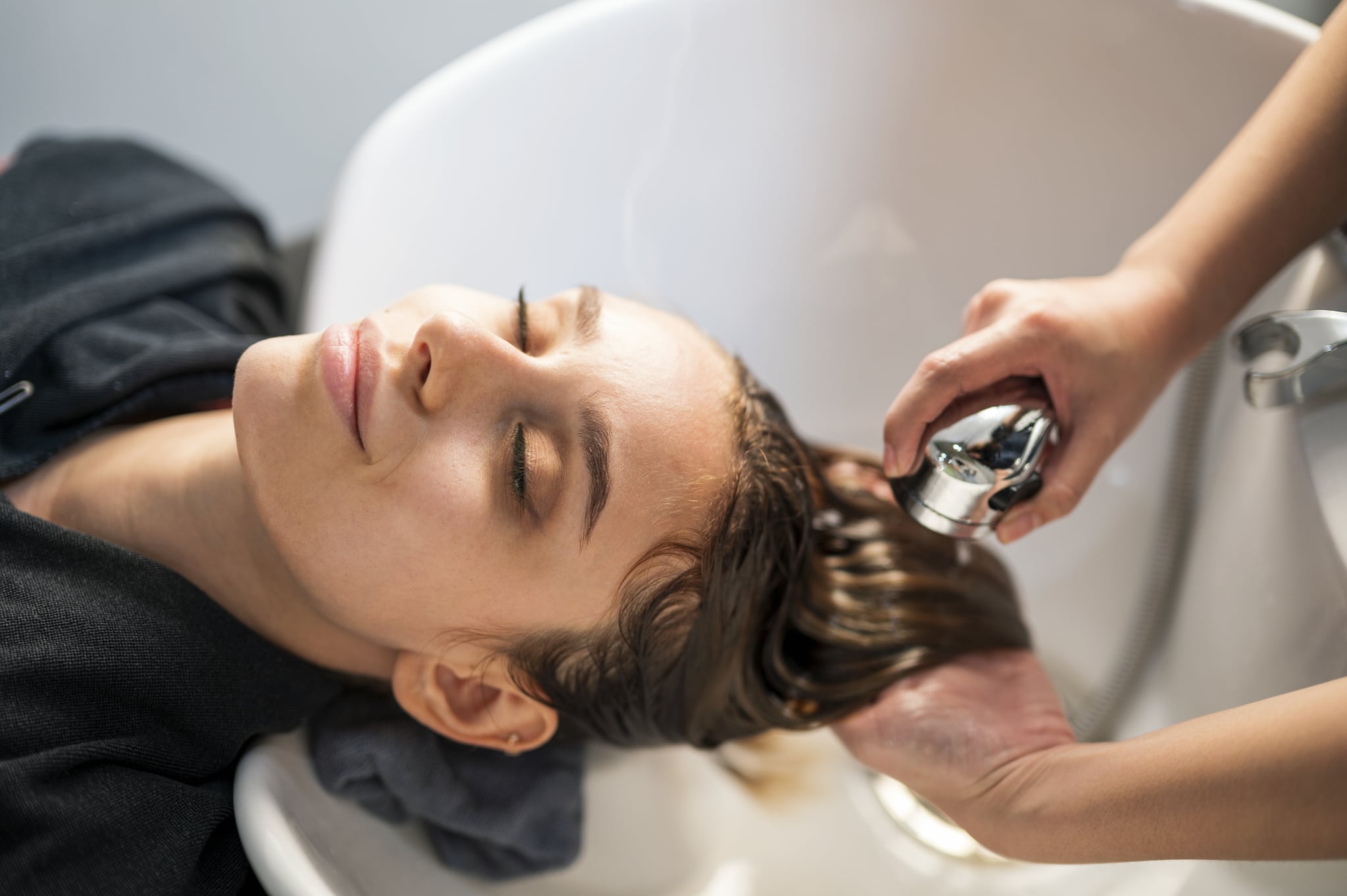 Young women customer washing her hair by beautician after dye hair at beauty salon. Beauty Salon business.