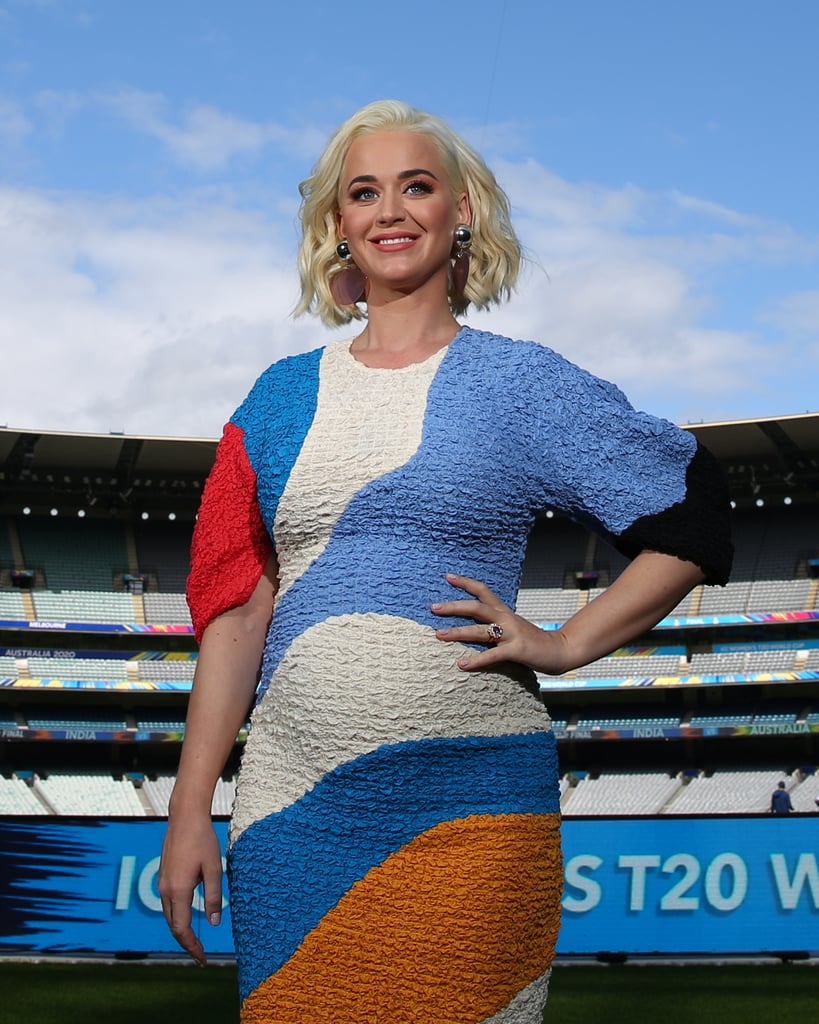 Katy Perry has that pregnancy glow! On Saturday, the 35-year-old singer made her debut public appearance since announcing she and fiancé Orlando Bloom are expecting their first child together. Rocking a colorful, form-fitting Mara Hoffman dress, Katy showed off her subtle growing baby belly in Melbourne, Australia, where she was rehearsing for her upcoming performance at the ICC Women's T20 World Cup Final on March 8. The American Idol judge appeared to be in high spirits as she snapped photos with athletes and posed for some solo shots.
Katy confirmed she's expecting in the "Never Worn White" music video on March 4. "Omg so glad I don't have to suck it in anymore," she joked on Twitter after the big reveal. While this will be Katy's first baby, Orlando shares 9-year-old son Flynn with ex-wife Miranda Kerr. Look ahead to see Katy proudly modeling her pregnancy ahead of her World Cup staging!