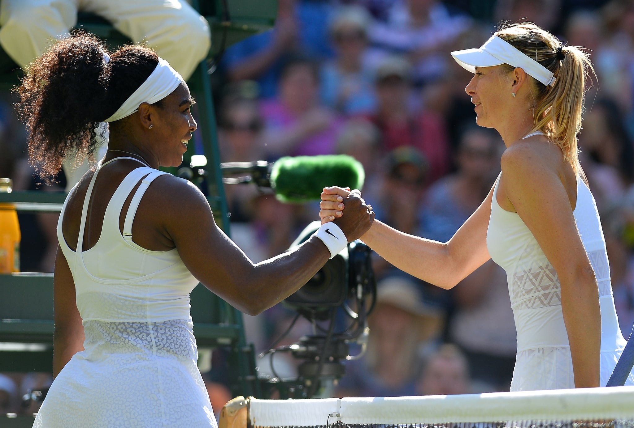 US player Serena Williams (L) shakes hands with Russia's Maria Sharapova (R) after Williams won their women's semi-final match on day ten of the 2015 Wimbledon Championships at The All England Tennis Club in Wimbledon, southwest London, on July 9, 2015. Williams won 6-2, 6-4.  RESTRICTED TO EDITORIAL USE  --    AFP PHOTO / GLYN KIRK        (Photo credit should read GLYN KIRK/AFP/Getty Images)