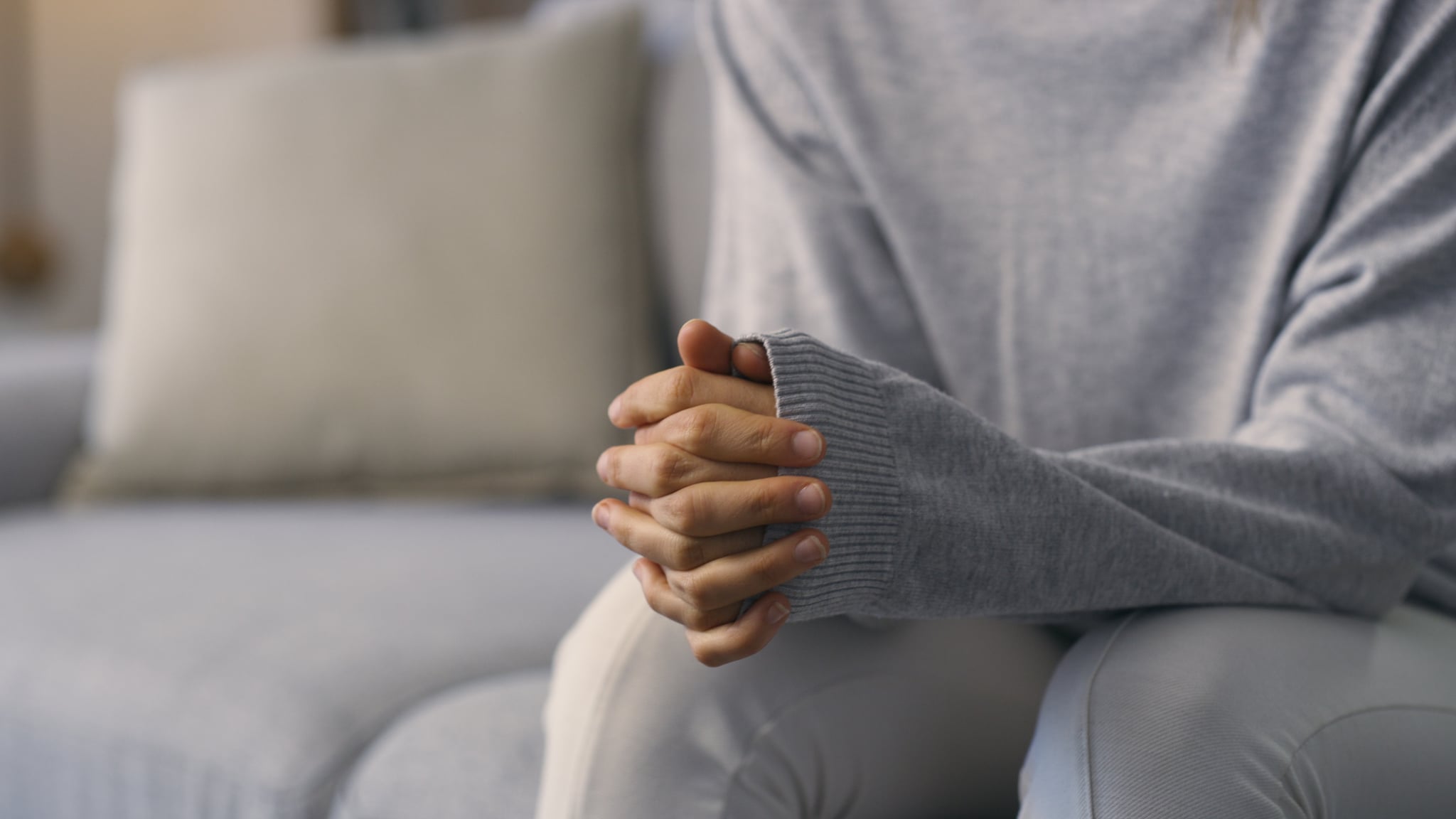 Woman clasping hands in anxiety before a EMDR therapy session