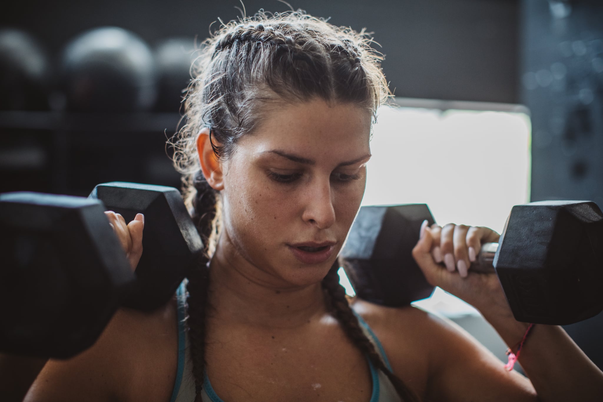 Woman weightlifting with dumbbells in gym