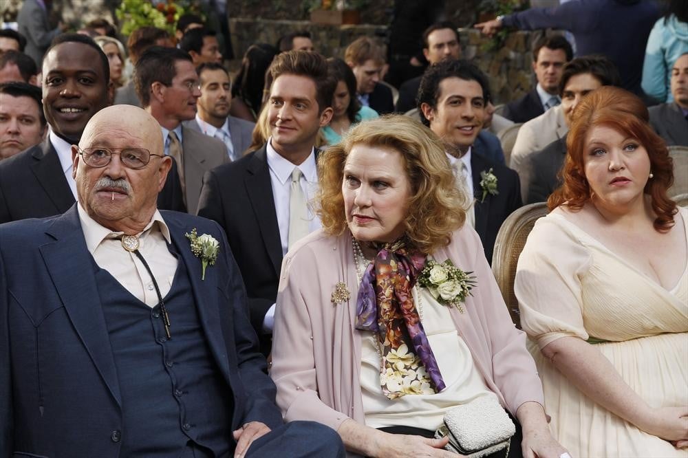 Merle (Barry Corbin), Barb (Celia Weston), and Pam (Dana Powell) sit in the audience.