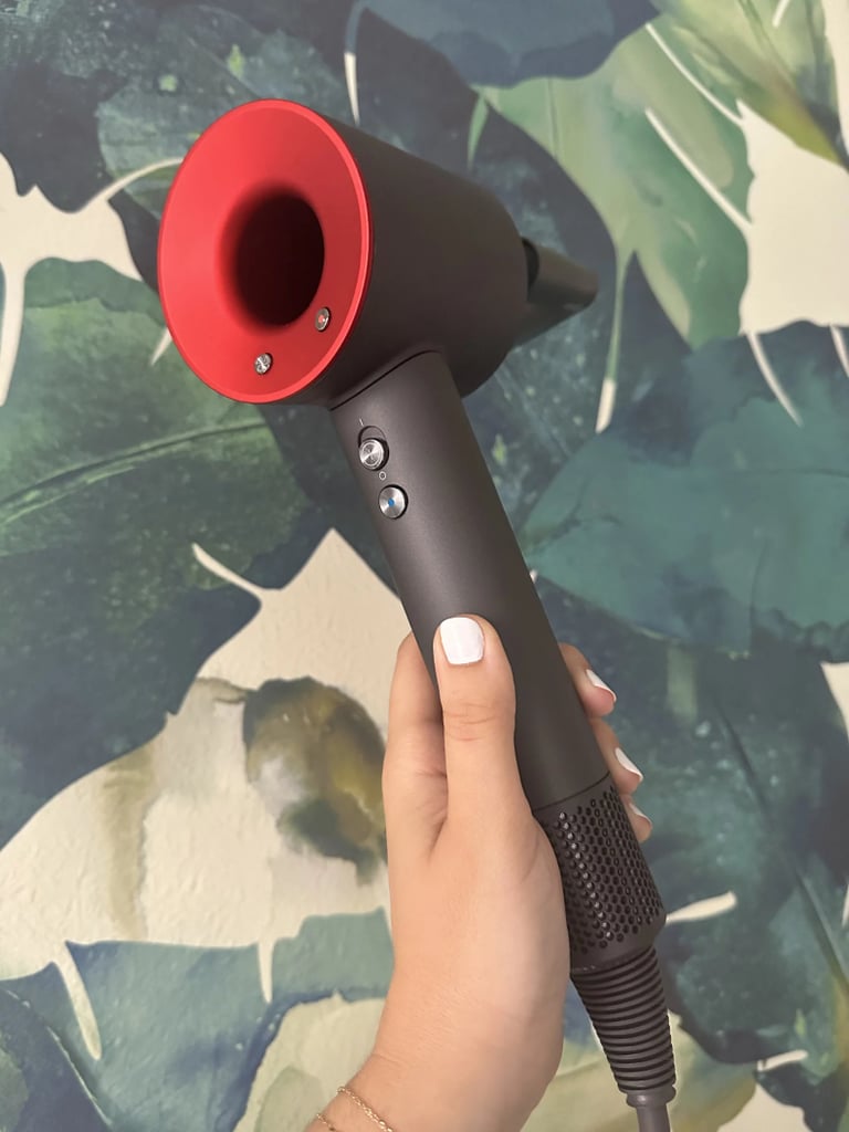 Dyson Supersonic Hair Dryer ($520)
Dyson's classic Supersonic Hair Dryer is a tried-and-true favorite by beauty lovers and professional hairstylists alike. It has a powerful motor that produces high-pressure, high-velocity air to help dry your hair quickly, and it's suitable for all hair types. It's equipped with three heat settings, a cold shot, and three speed settings. This is ideal for those who want an efficient standard hair dryer that is speedy and reliable. Read our review of Dyson's Supersonic Hair Dryer for more. 
Attachments: A styling concentrator, a diffuser, a gentle air attachment, a wide-tooth comb, and a flyaway attachment. 
Editor Quote: "I never used to blow-dry my hair because it would take longer than I had the patience for (which, admittedly, wasn't very much), and it'd leave my wavy hair with a halo of frizz. All it took was using the Supersonic Hair Dryer once, though, to discover that it would challenge everything I knew. What's most impressive to me is how fast it works. Rough-drying my hair with the gentle air attachment takes 10 minutes, tops....What's also worth noting is how shiny it makes your hair. You can see a real difference in mine when I air-dry it or use a different hot tool." - Jessica Harrington, beauty section lead
