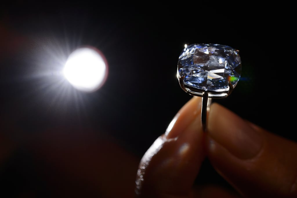 A model held the over 12-carat blue diamond that sold for $48 million at Sotheby's in Geneva.