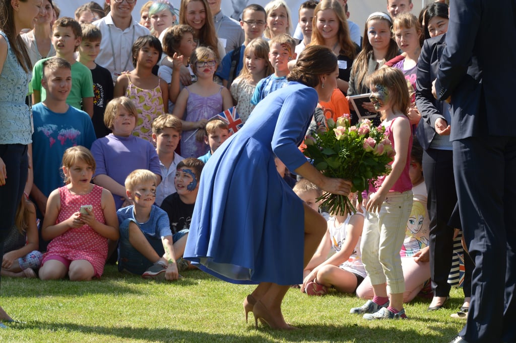 Heels in grass, thigh-high slit, giant bouquet — the obstacles are endless, and yet, she continues to hold her position.