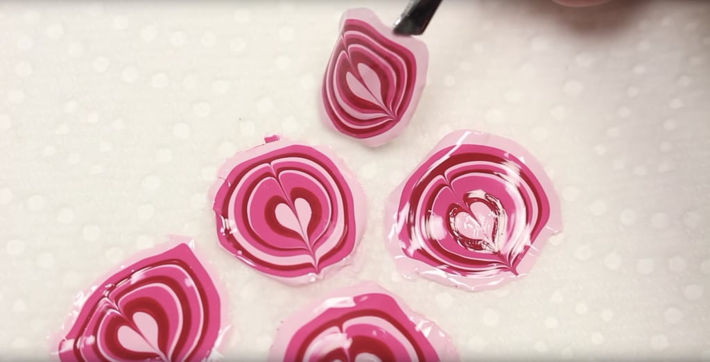After the polish is dry, make sure the design is detached from the cap before you remove it.
Carefully remove the design from the cap with tweezers.
Let the designs rest on a paper towel to soak up any excess water.