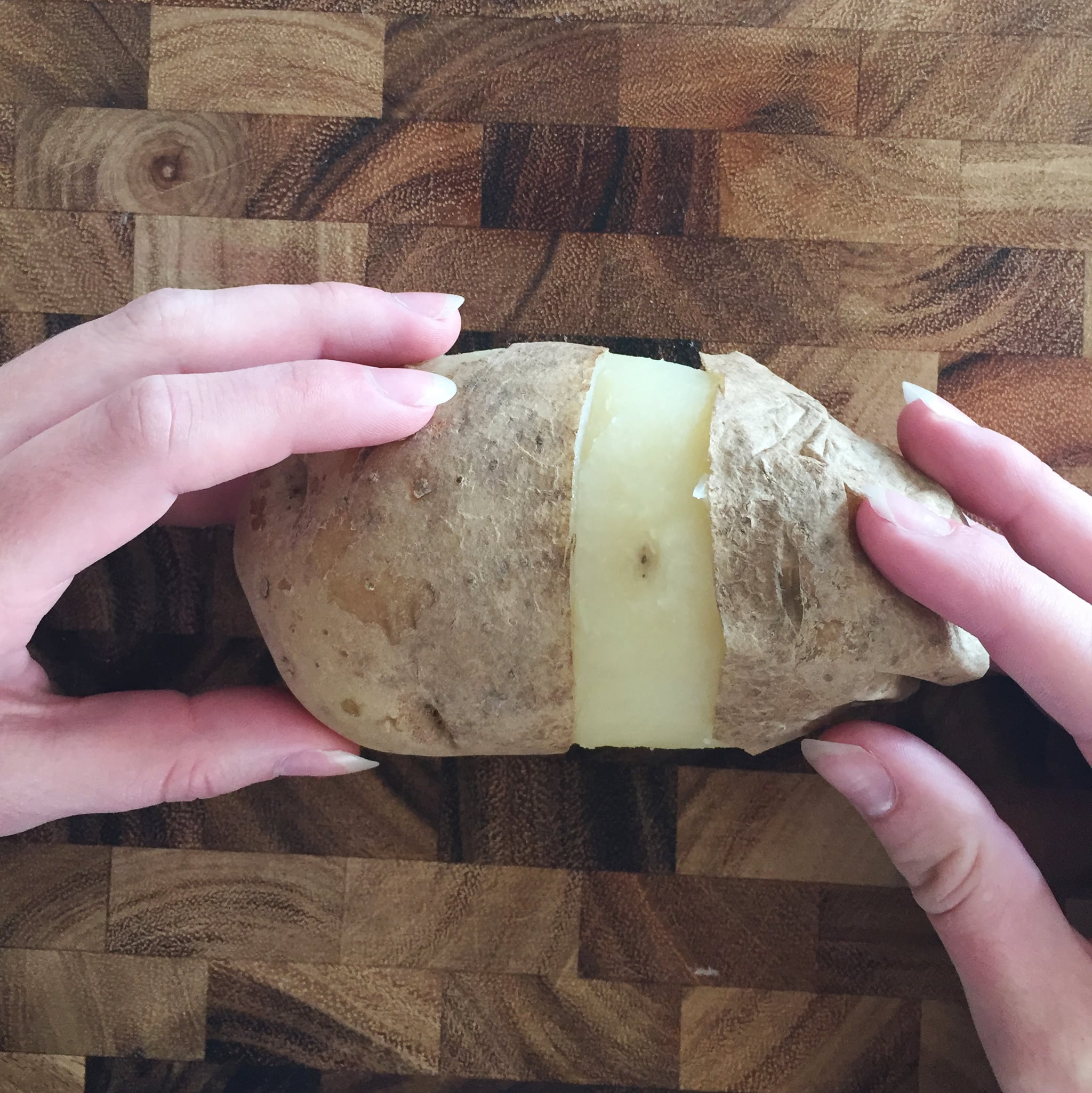 Woman hold potato on cutting board