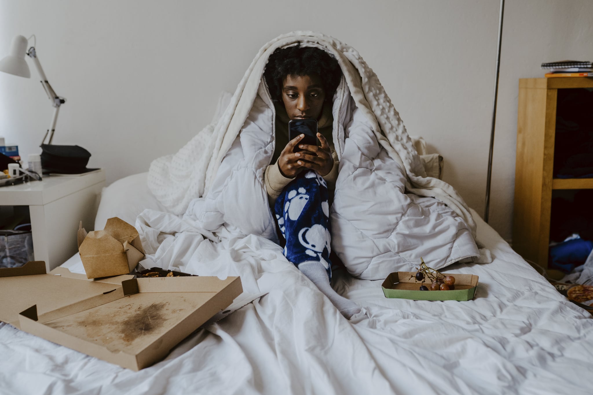 Woman in bed stressed looking at phone