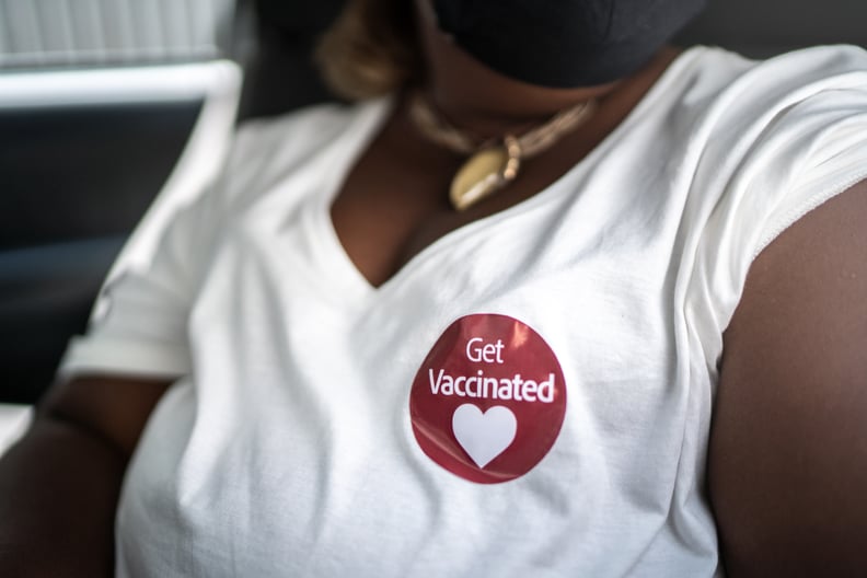 'Get vaccinated' sticker in a woman's shirt in a drive through