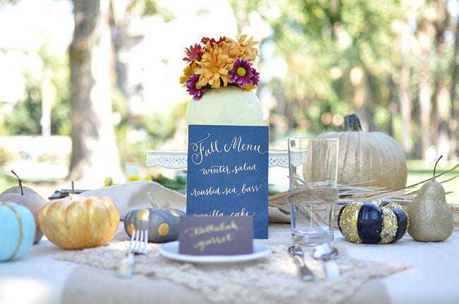 For an autumnal touch, paint pumpkins your wedding colors and scatter them across the table.