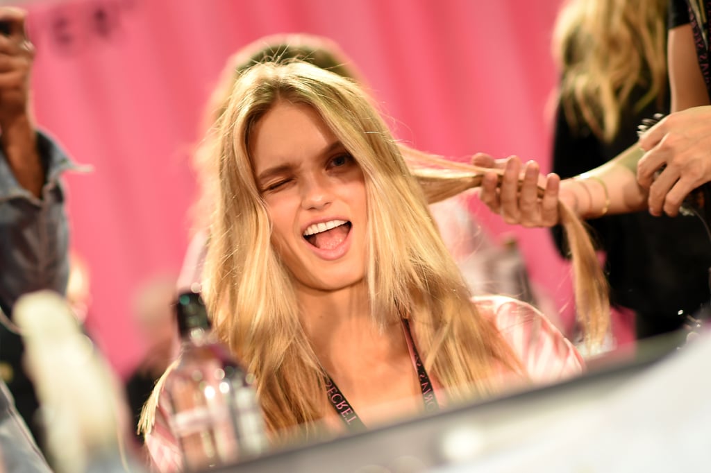 Romee Strijd winks coyly as she gets her strands touched up.