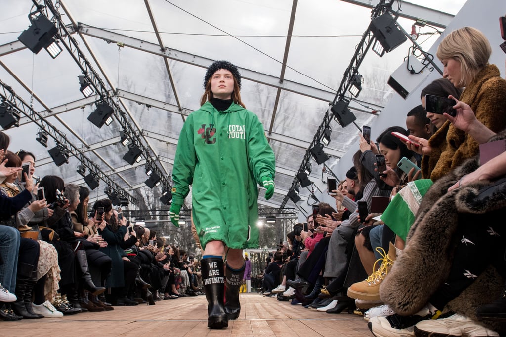 Sadie Sink in an Undercover raincoat and matching rain boots.