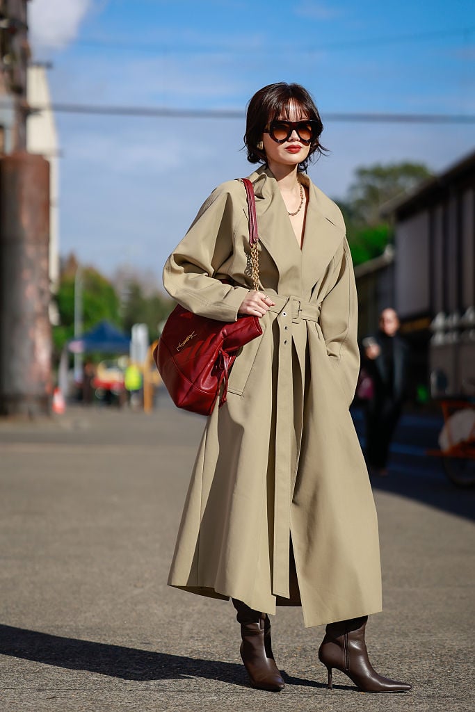 A red bag to pop against a tan trench and brown leather boots.
