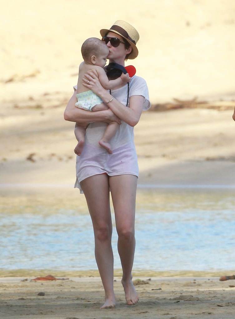 On Thursday, Anne Hathaway kissed a baby while walking on the beach in Hawaii with friends.