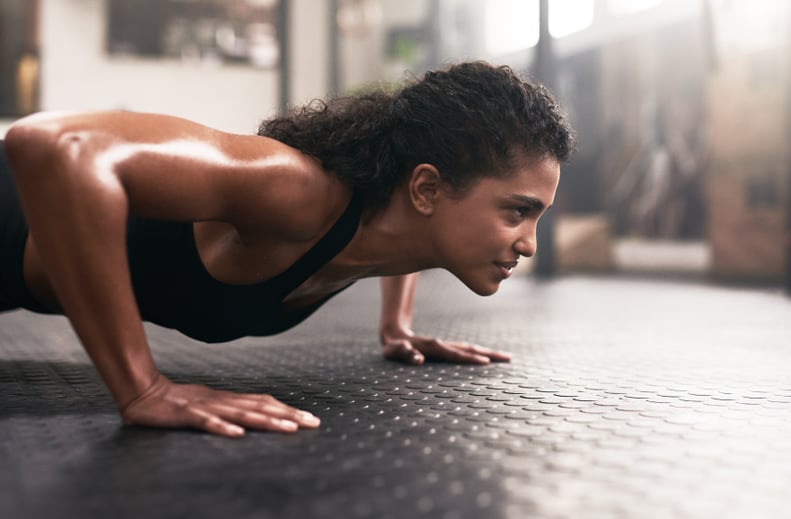 Shot of a sporty young woman doing pushups in a gym