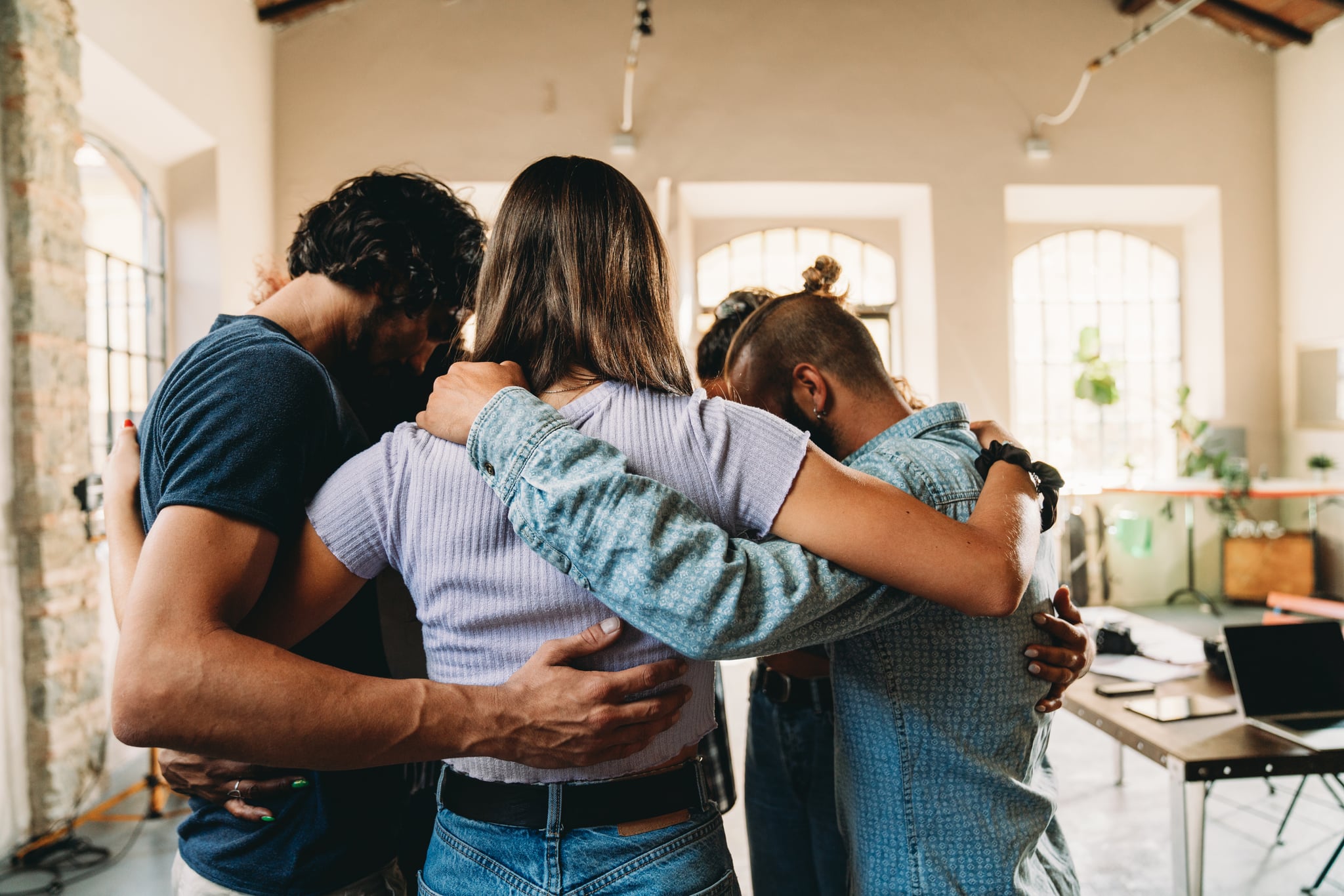 People embracing together in their office. Team building concept. Teamwork of people.