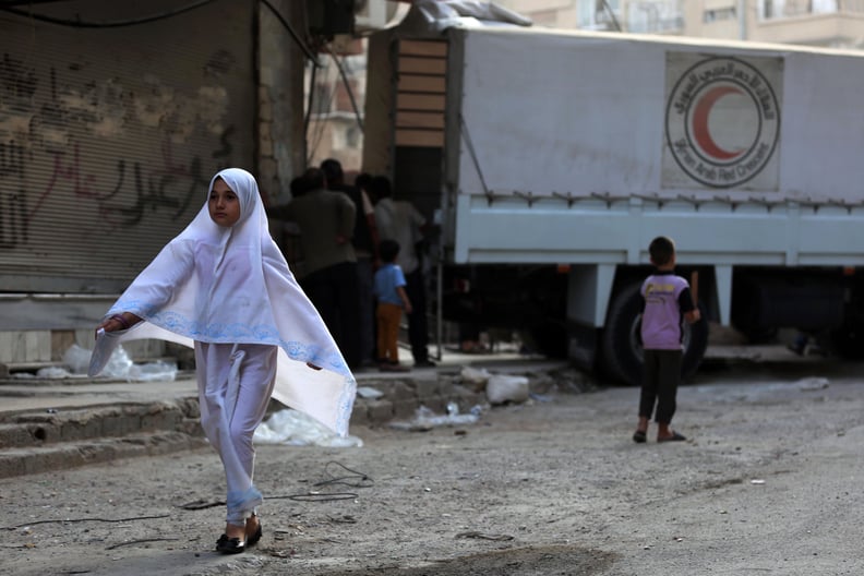 A young girl walks from an aid truck in a rebel-held town near Damascus.