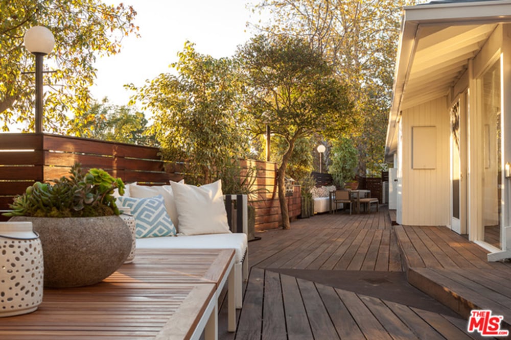 Rich wood planking is used in the home's fence and deck and around the pool and spa.