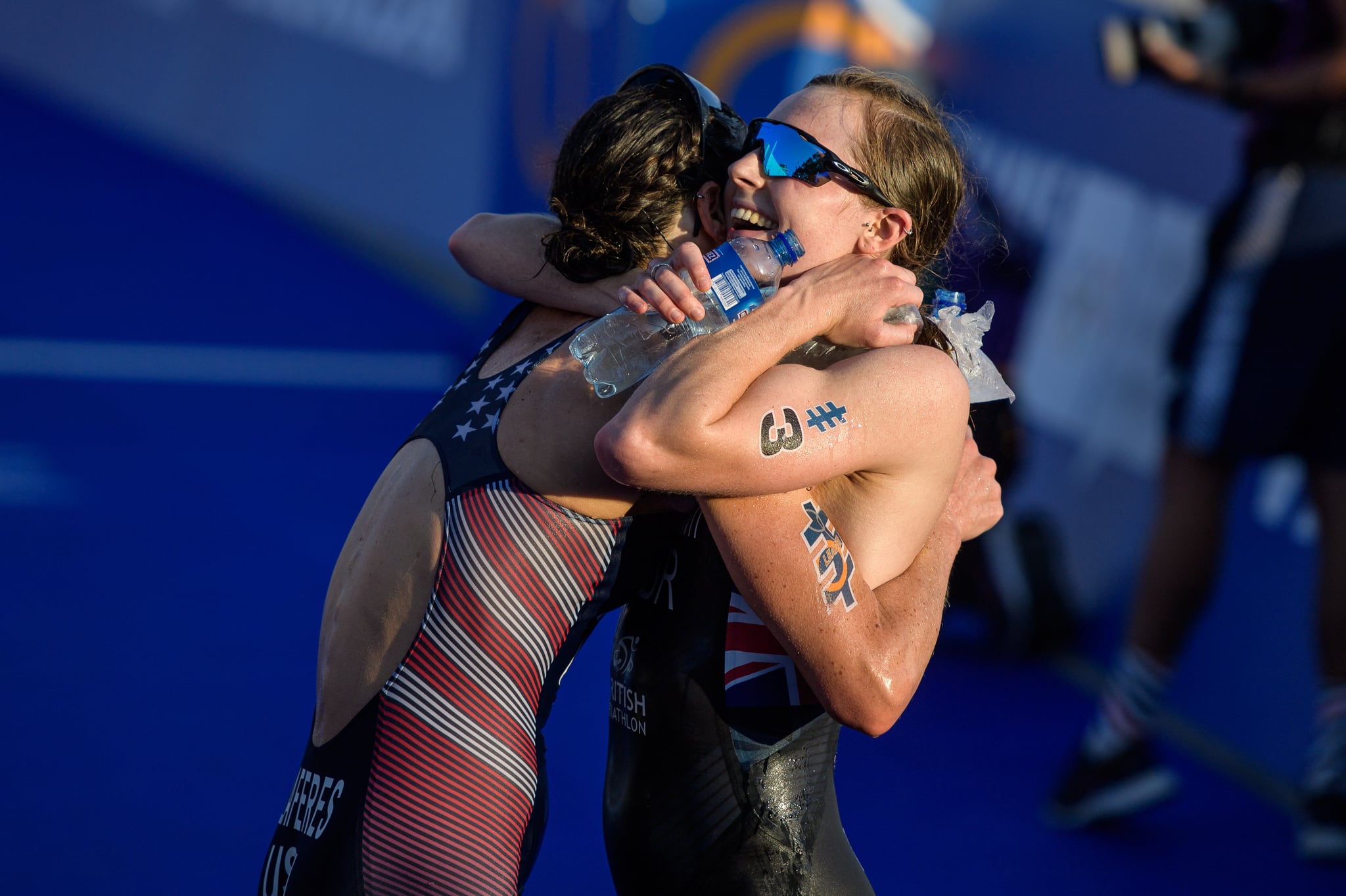LAUSANNE, SWITZERLAND - AUGUST 31: Georgia Taylor-Brown of Great Britain gives Katie Zaferes of the United states a hug after the women's elite olympic race at the ITU World Triathlon Grand Final on August 31, 2019 in Lausanne, Switzerland. (Photo by Jörg Schüler/Getty Images)