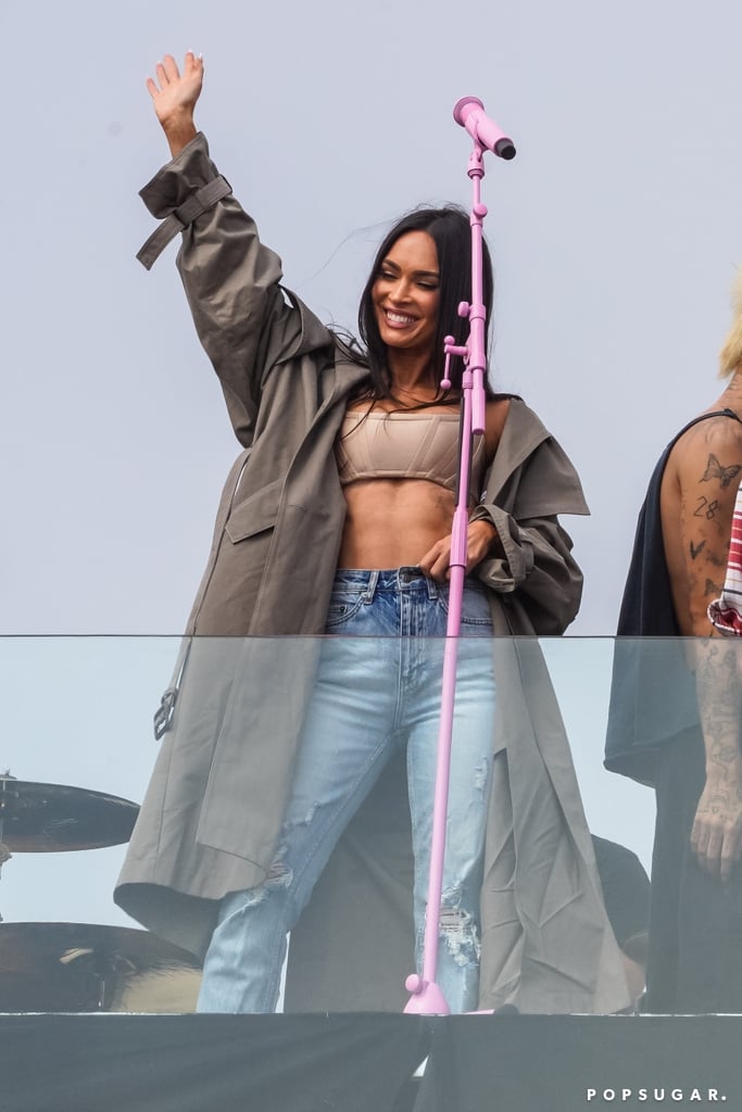 If there's such thing as the queen of crop tops, Megan Fox is coming for the throne. The Till Death actress appears to love an ab-baring tee or exposed bra when she's out and about. Such was the case when she showed up to support boyfriend Machine Gun Kelly at his secret Venice show on Saturday. She spent the event chilling with Kourtney Kardashian and Addison Rae, and even waved to the crowd at one point, giving everyone a view of her entire ensemble. 
As the summer sun rolls around and the temperature starts to heat up, Megan could teach a course on how to style the shortest of shirts. For the concert, she chose a beige structured crop top and an oversize trench coat, plus distressed Ksubi jeans and a pair of sparkling platform heels. Keep the classic crops coming all summer long, Megan! Get a closer look at her full outfit, ahead. 

    Related:

            
            
                                    
                            

            We Need to Discuss Megan Fox&apos;s Outfits in the 2009 Movie Jennifer&apos;s Body