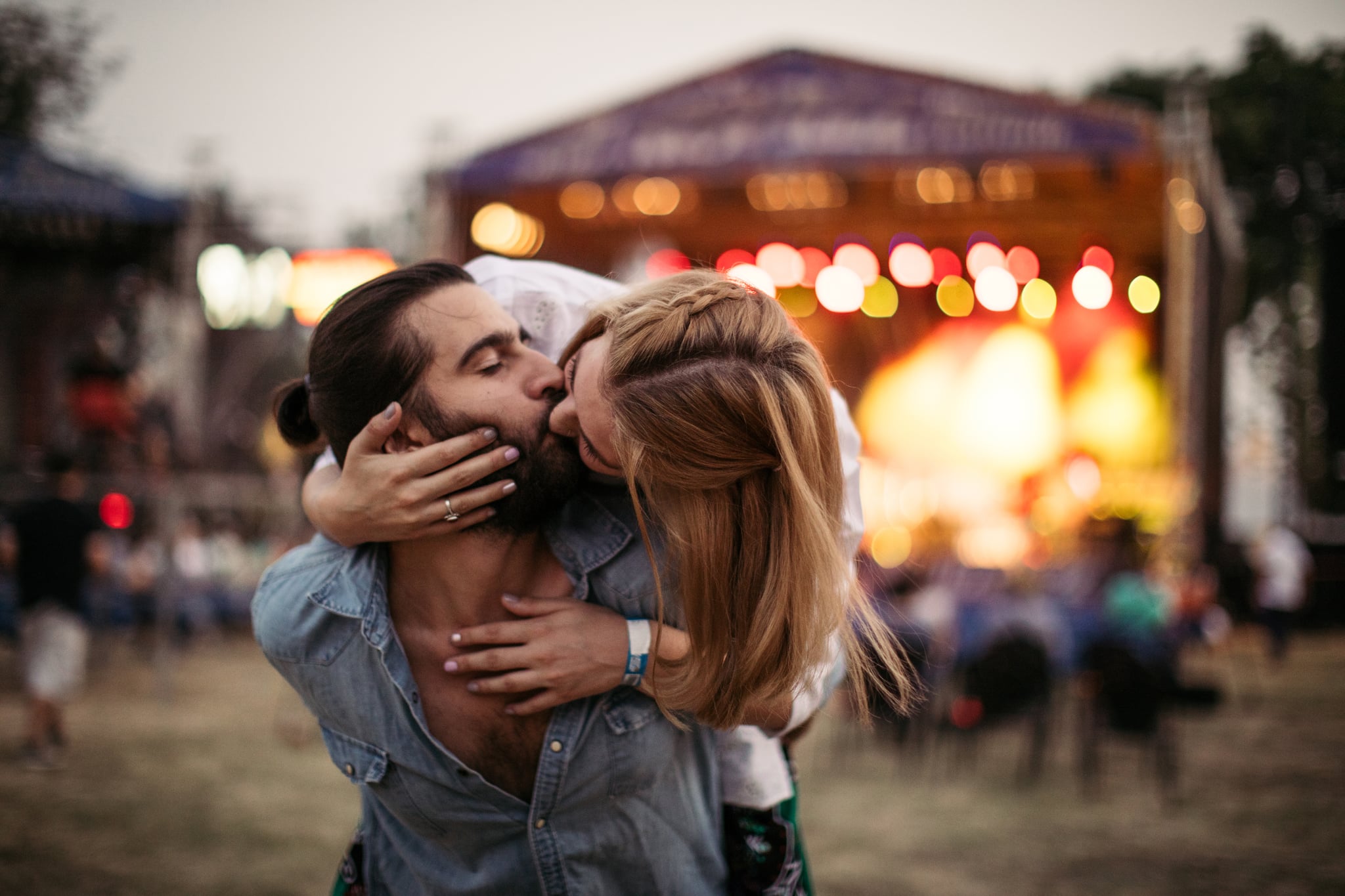Young couple, kissing on a concert, summer festival.
