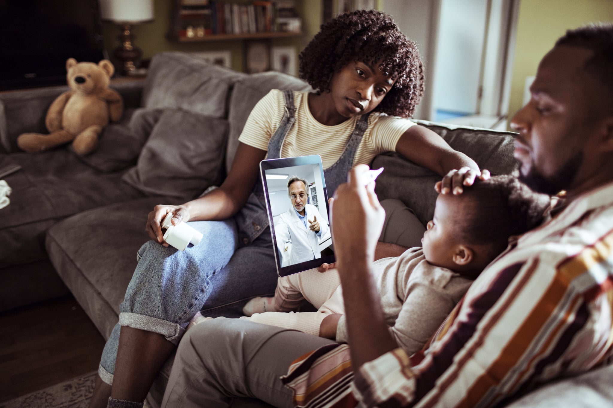 Close up of a young family consulting with their doctor over a digital tablet