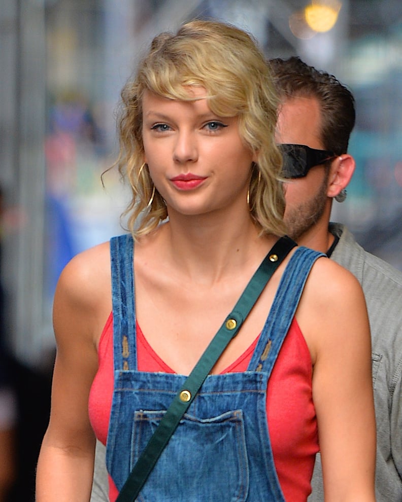 Taylor Swift steps out in a leggy pinafore dress in NYC, sporting kooky bedhead curls