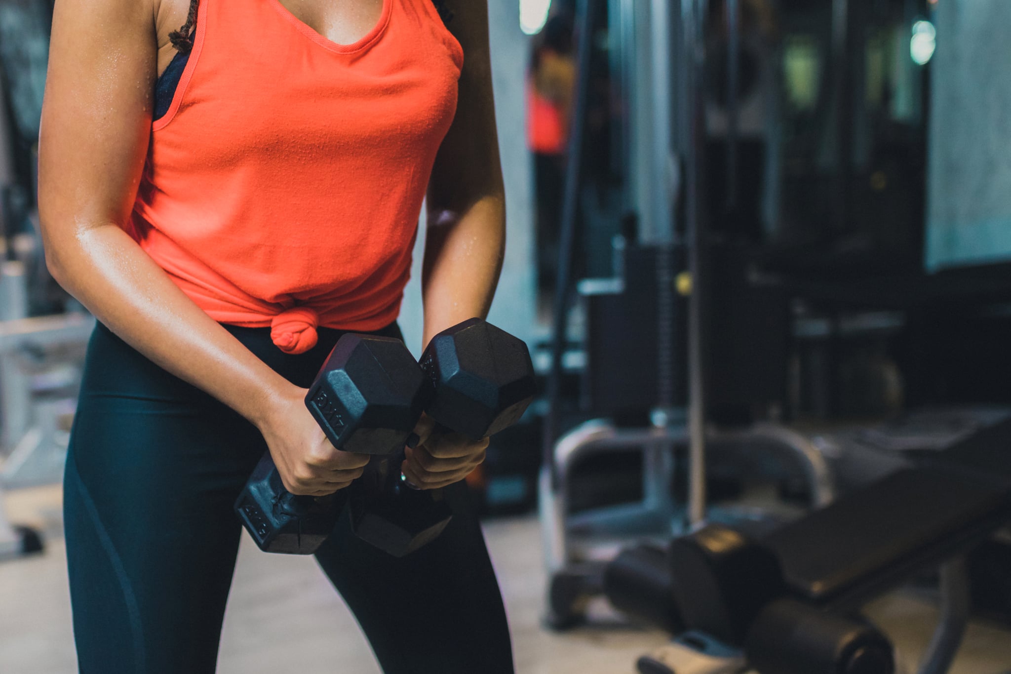 person holding dumbbells in gym representing how to choose the right weight while strength training