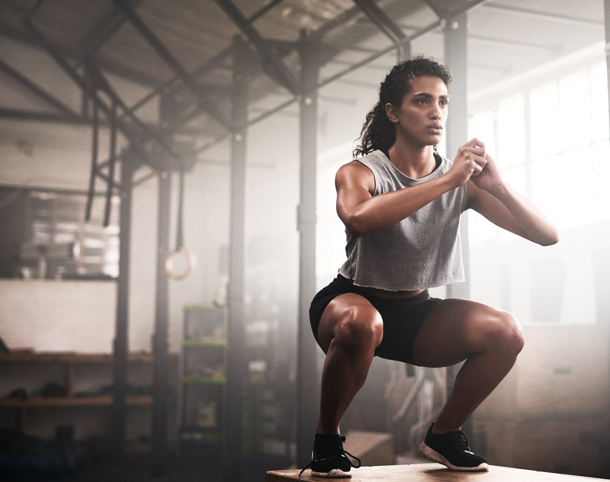 Shot of a sporty young woman box jumping in a gym