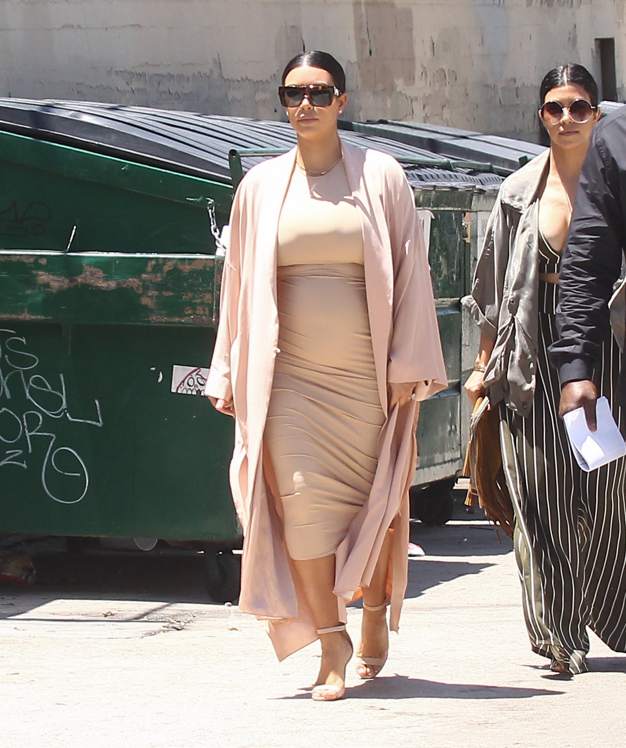 Kim covered her sand-colored midi with 