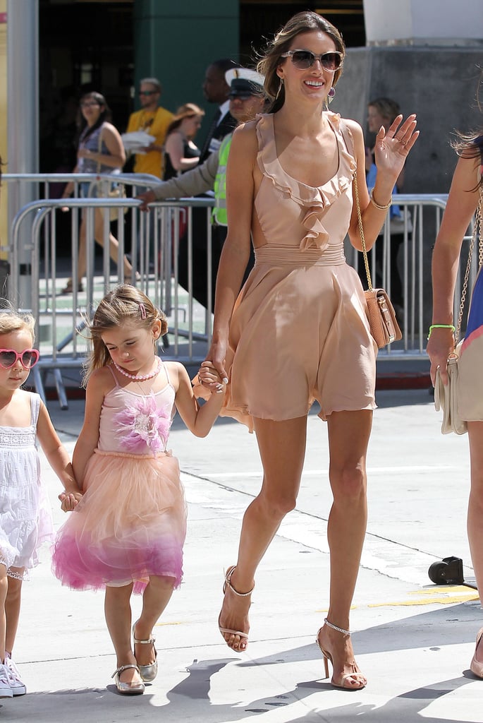 Alessandra waved in a peachy ruffled minidress and matching ankle-strap sandals in LA.