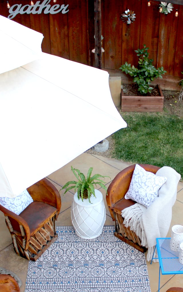 Tip #4: Create a Space to Lounge
Once you've established your outdoor dining area, consider adding a cozy lounging spot for enjoying cocktails or just curling up with a book on the weekend. Laying down a small area rug can make a couple of chairs suddenly feel like an outdoor room. 
This one is made from recycled plastic bottles ($70) and is even reversible. Two looks for one! Finish by adding throw pillows, a blanket, and a side table or two.